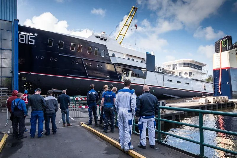 a group of people standing outside a large ship aboard SHERPA Yacht for Sale
