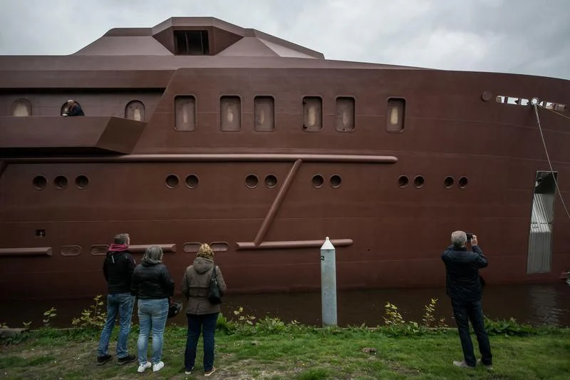 a group of people standing in front of a large brick building aboard SHERPA Yacht for Sale