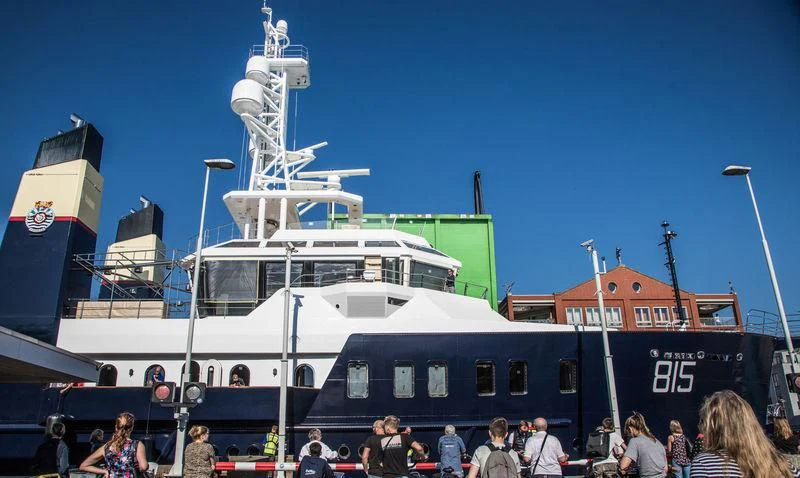 a group of people standing next to a large white boat aboard SHERPA Yacht for Sale