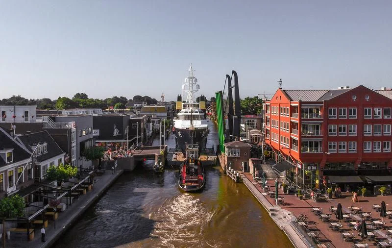 a canal with boats and buildings aboard SHERPA Yacht for Sale