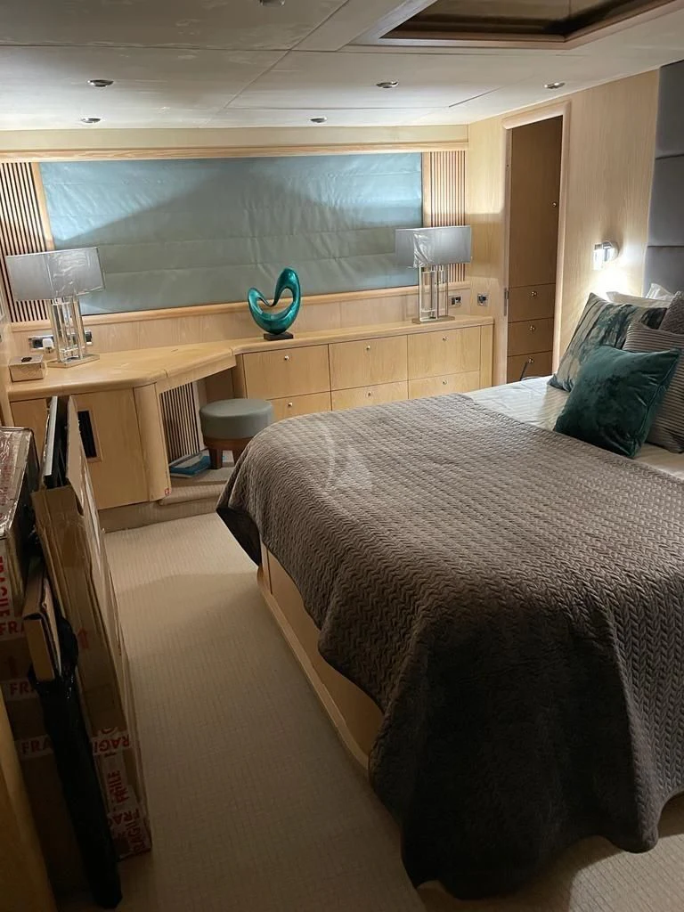 a bedroom with a bed and desk aboard EXCELERATE Z Yacht for Sale