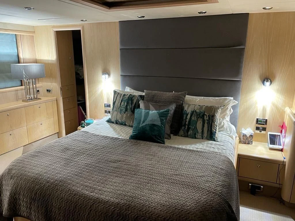 a bed with a black and white comforter and pillows aboard EXCELERATE Z Yacht for Sale