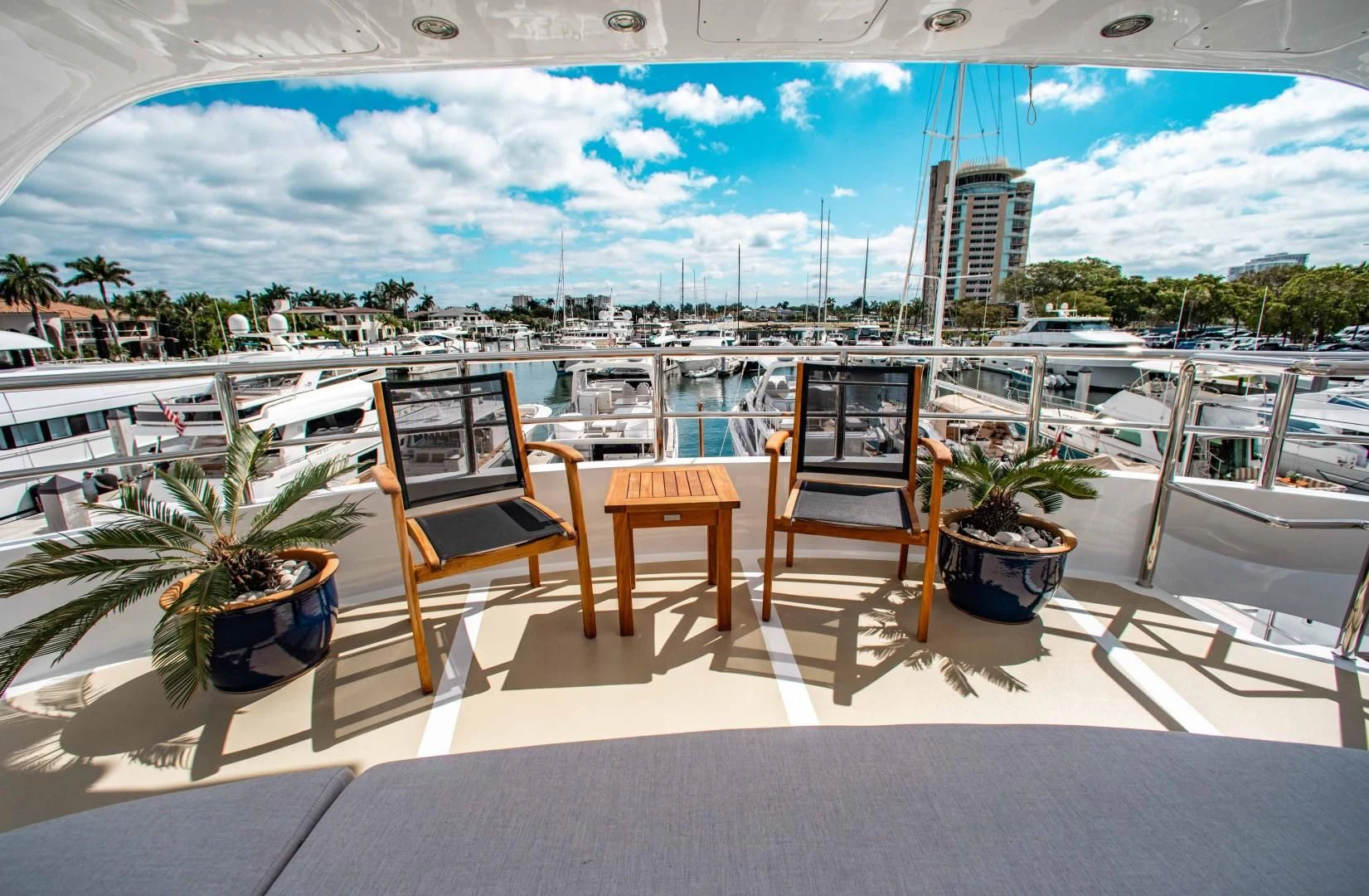 a table and chairs on a deck overlooking a marina aboard DRIVEN Yacht for Sale