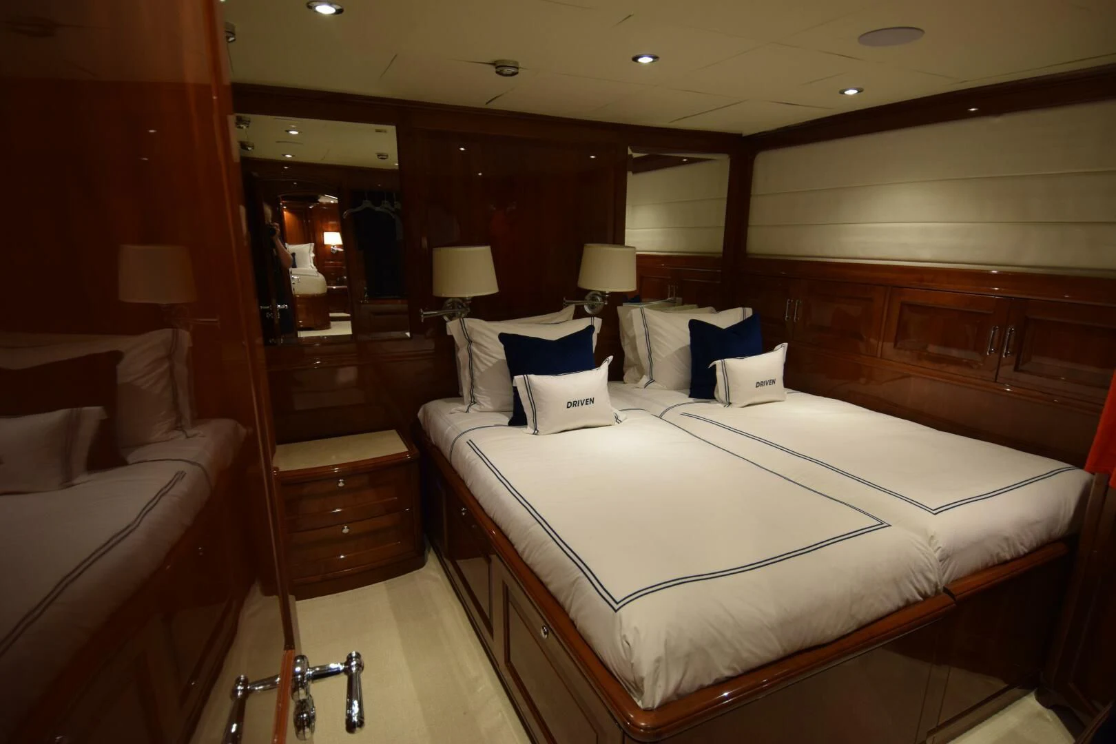 a room with a bed and a mirror aboard DRIVEN Yacht for Sale