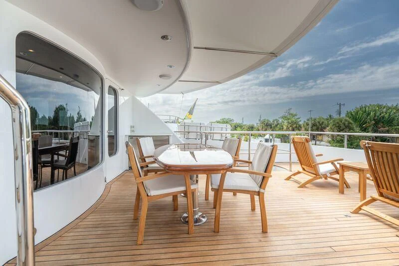 a deck with a table and chairs on it aboard DRIVEN Yacht for Sale