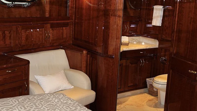 a room with a bed and a dresser aboard DRIVEN Yacht for Sale