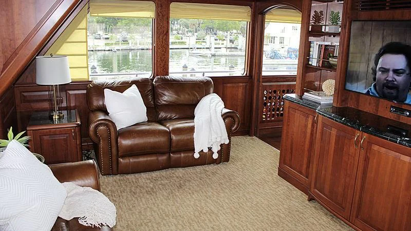 a person sitting in a chair in a living room aboard DRIVEN Yacht for Sale