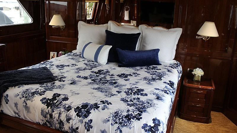 a bed with a white comforter and pillows aboard DRIVEN Yacht for Sale