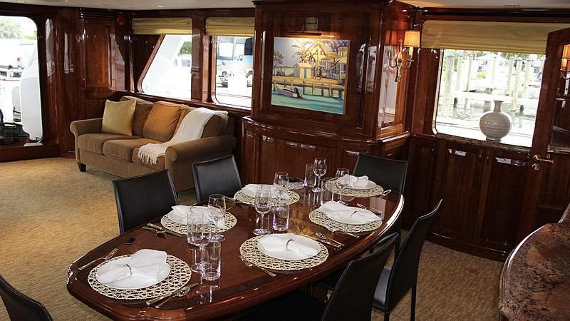 a dining table with plates and glasses aboard DRIVEN Yacht for Sale