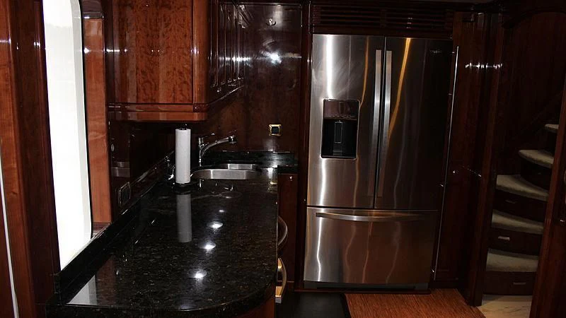 a kitchen with a stainless steel refrigerator aboard DRIVEN Yacht for Sale