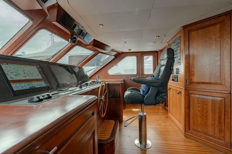 a room with a chair and a table and a cabinet aboard DRIVEN Yacht for Sale