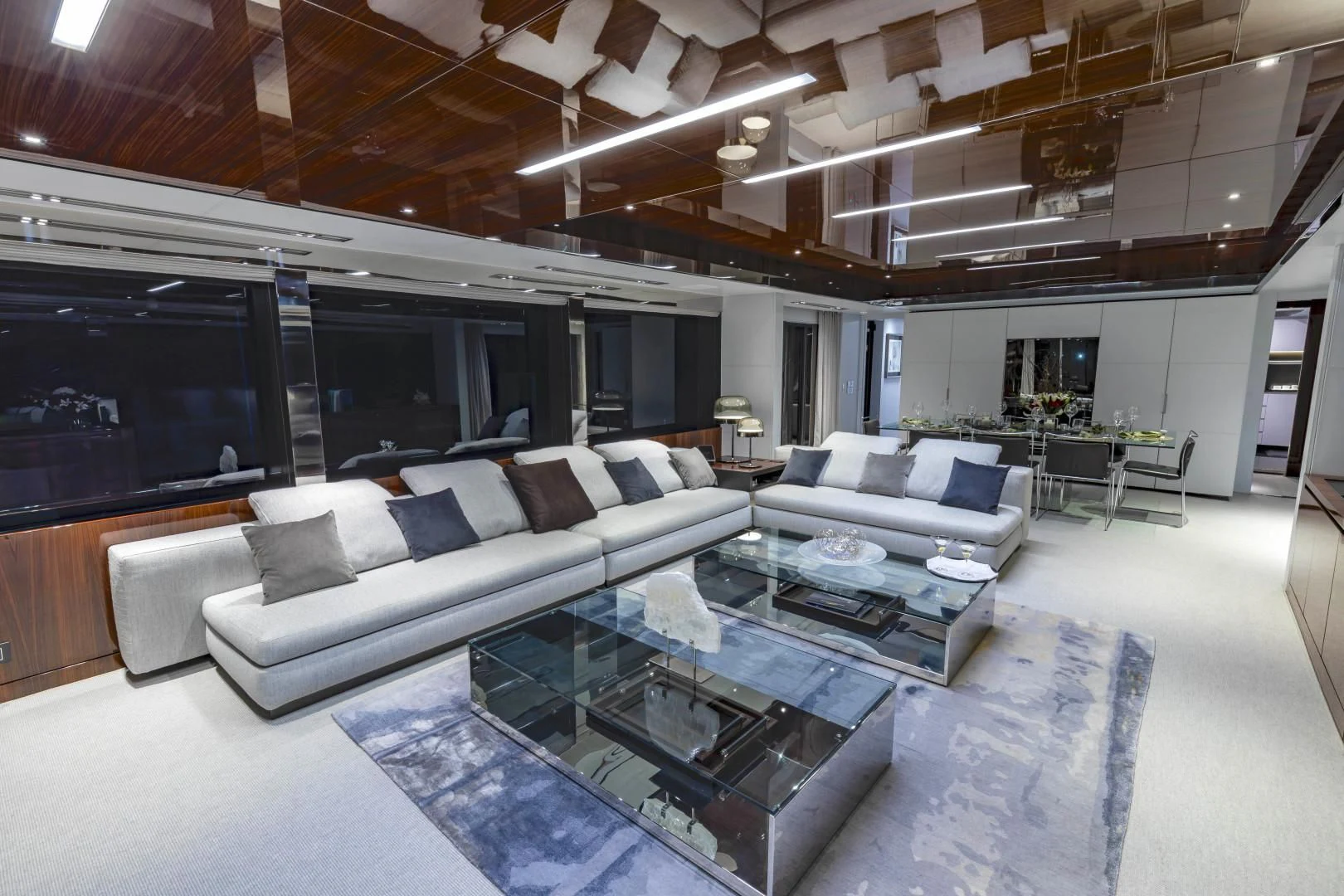 a living room with a large glass coffee table and a large window aboard NO SURRENDER Yacht for Sale