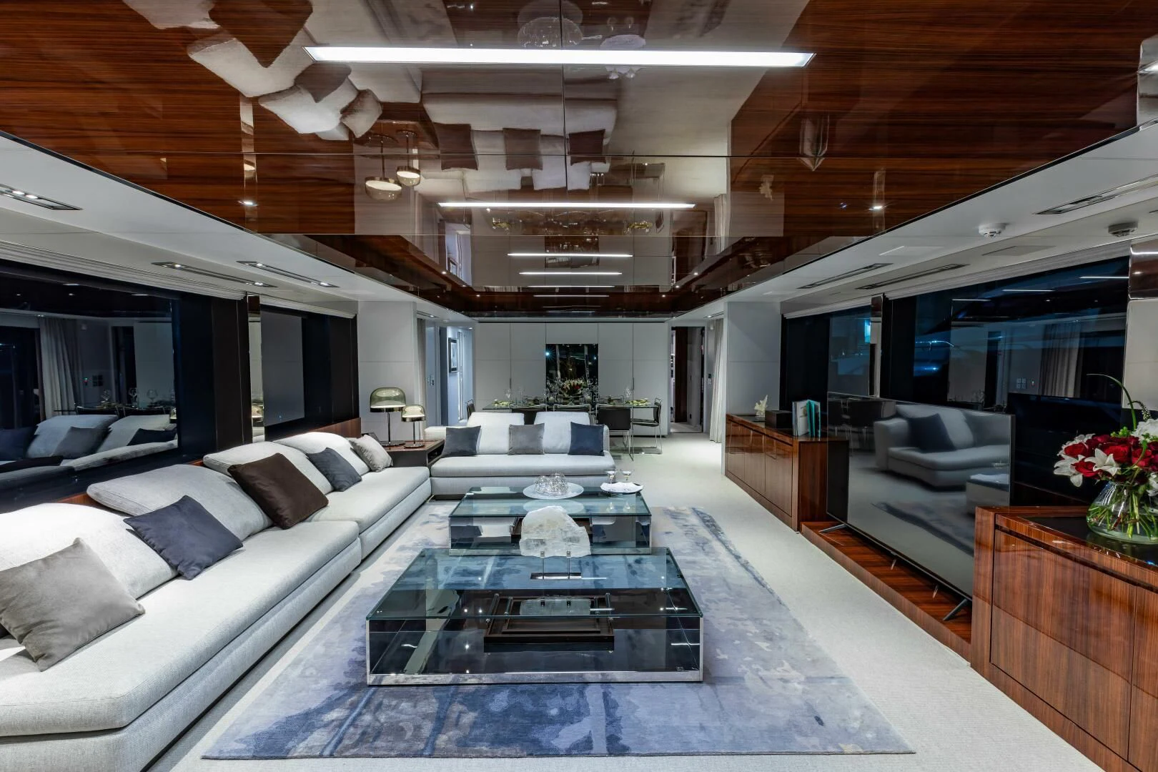 a living room with a large glass table and a large blue rug aboard NO SURRENDER Yacht for Sale