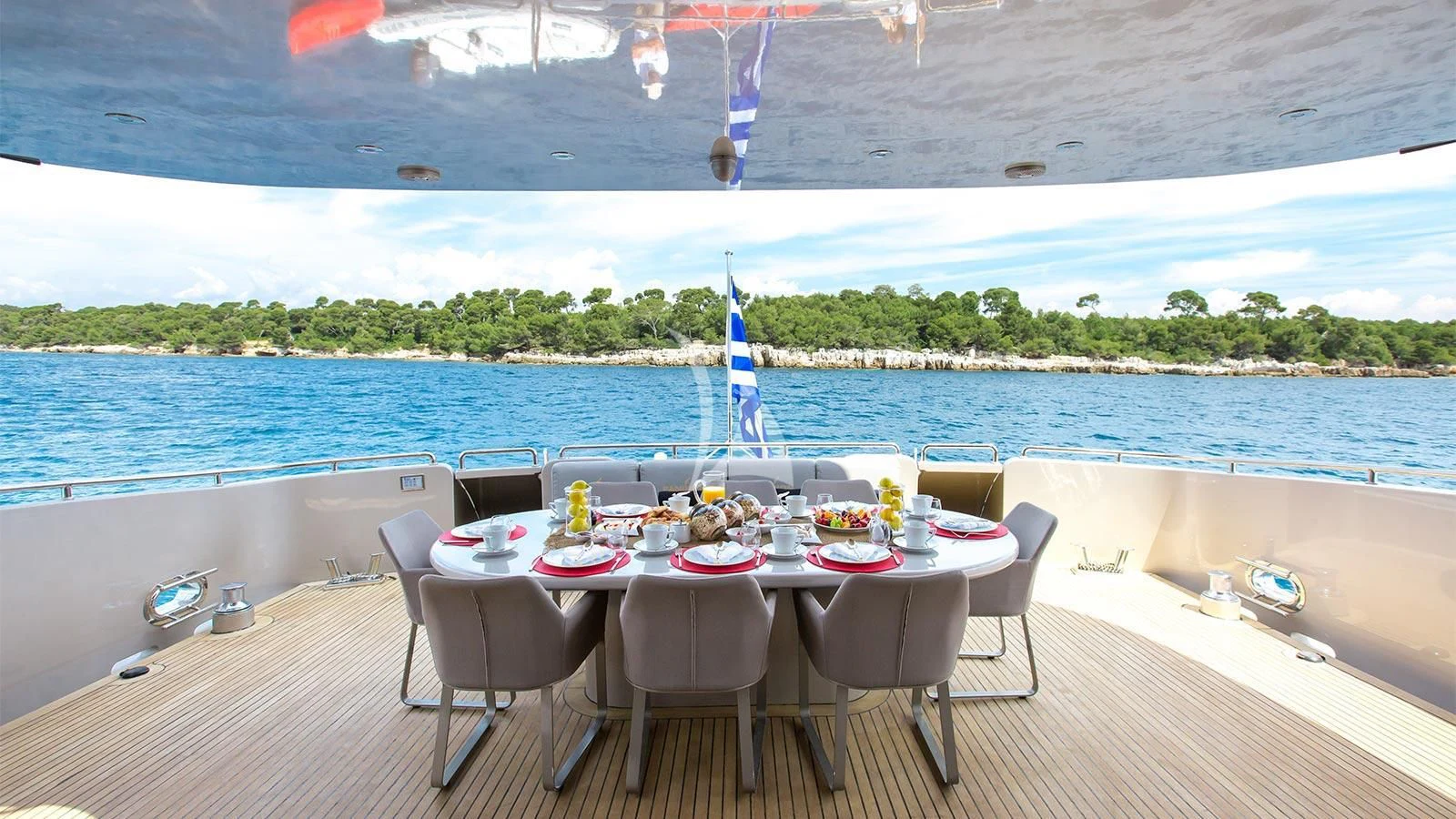 a table set for a meal on a beach aboard PANDION Yacht for Charter