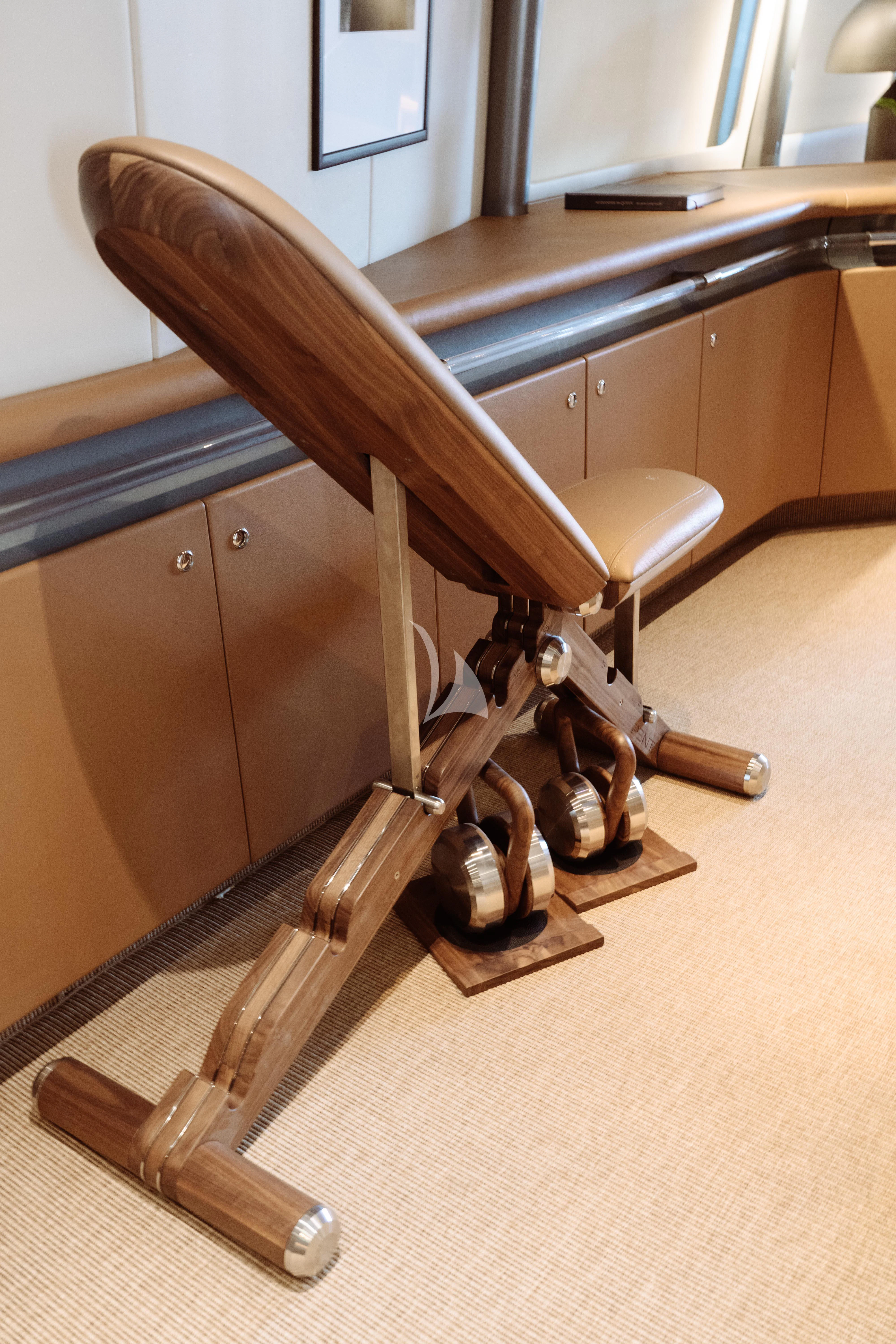 a wooden chair with a desk and a desk in the background aboard PANDION Yacht for Charter