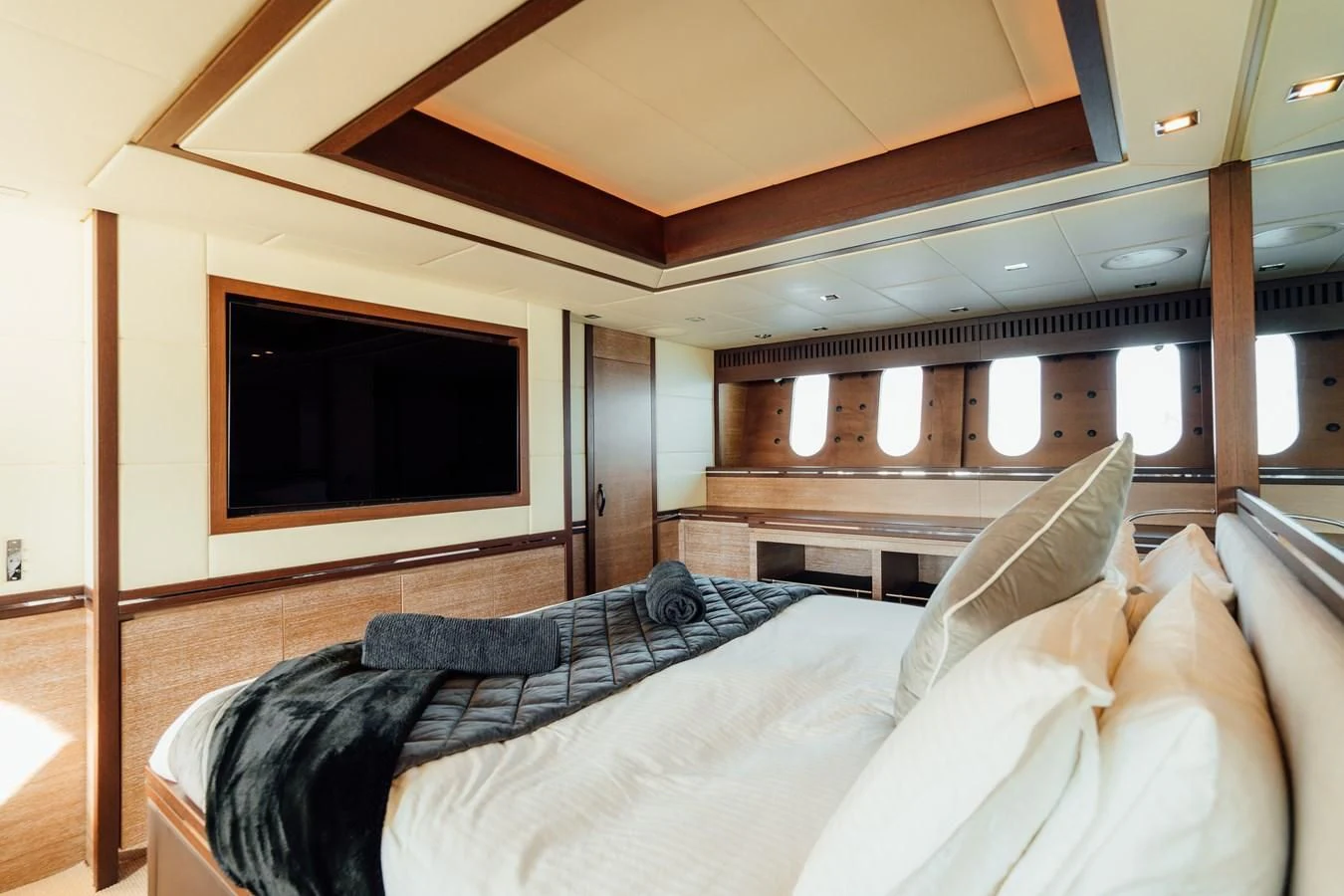 a bed with a television on the wall aboard YOLO Yacht for Sale