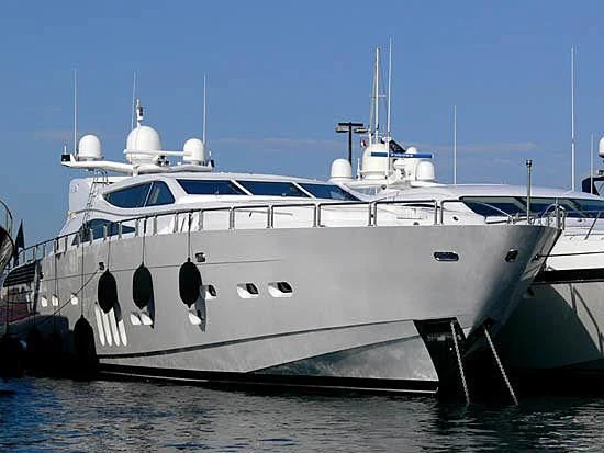 a large white boat with USS Potomac (AG-25) in the background aboard YOLO Yacht for Sale