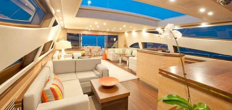 a room with a couch and a table and a large window aboard YOLO Yacht for Sale