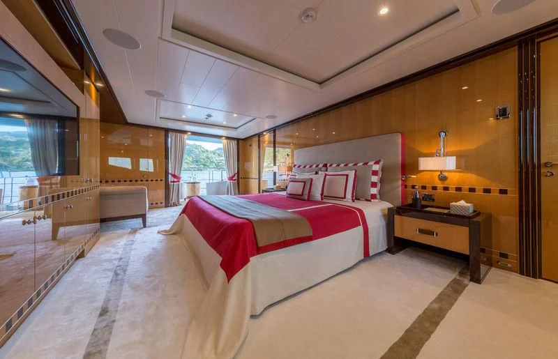 a bedroom with a bed and a dresser aboard ASTRA Yacht for Sale