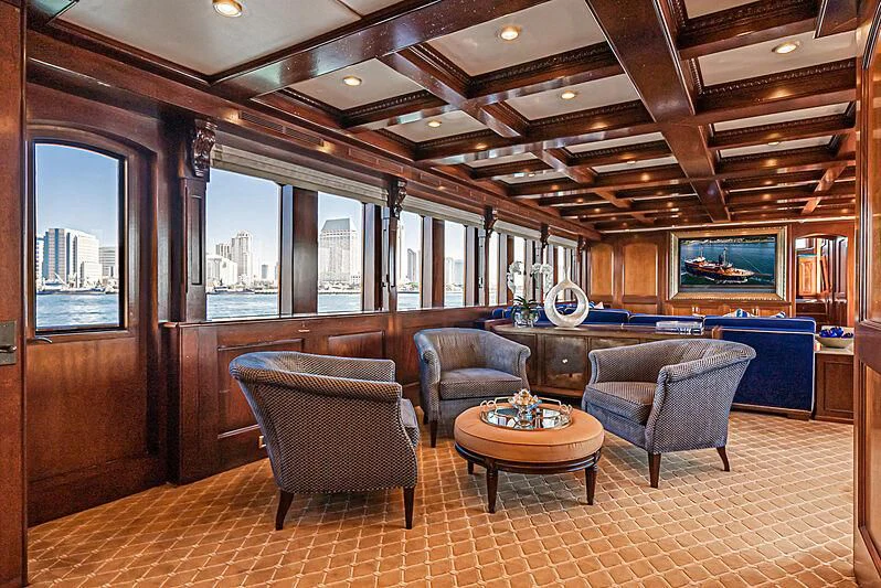 a living room with leather chairs and a bar aboard LADY BAHI Yacht for Sale