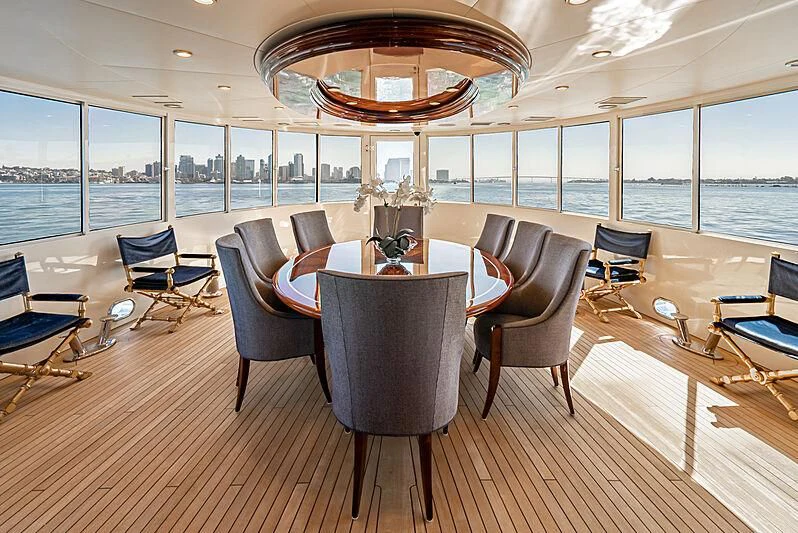 a large room with a table and chairs aboard LADY BAHI Yacht for Sale
