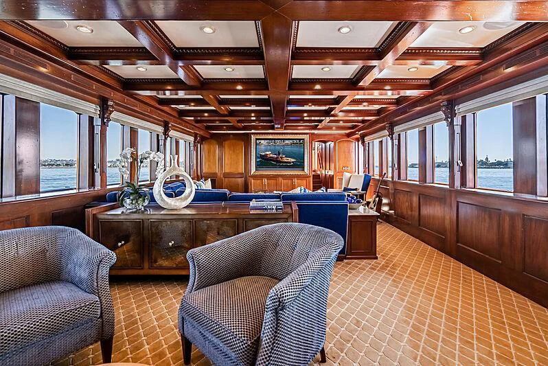 a room with a table chairs and a large window aboard LADY BAHI Yacht for Sale