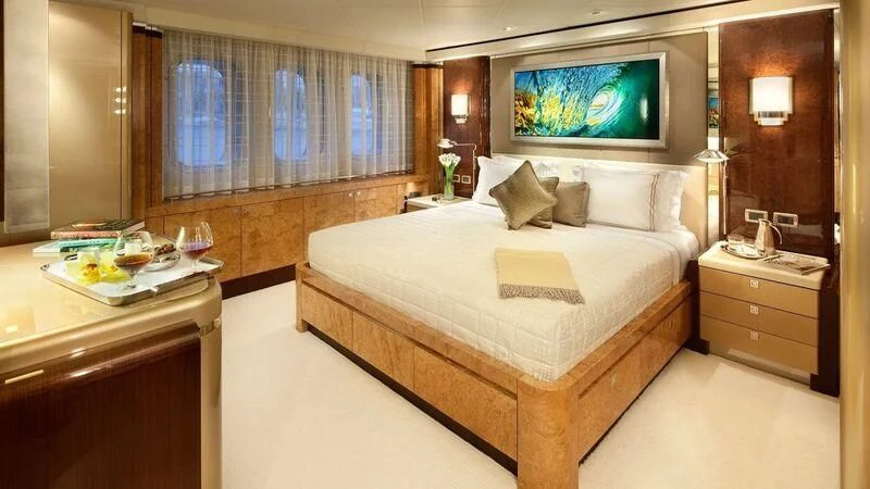 a hotel room with a bed and tv aboard SYCARA V Yacht for Sale