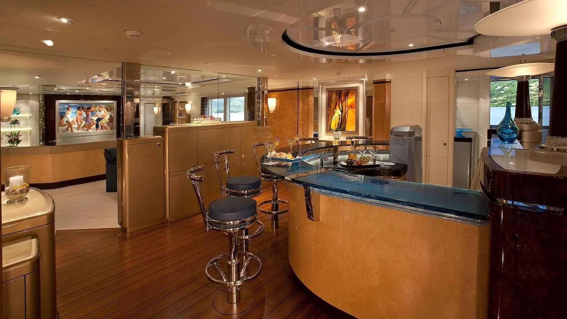 a large kitchen with a bar and bar stools aboard SYCARA V Yacht for Sale