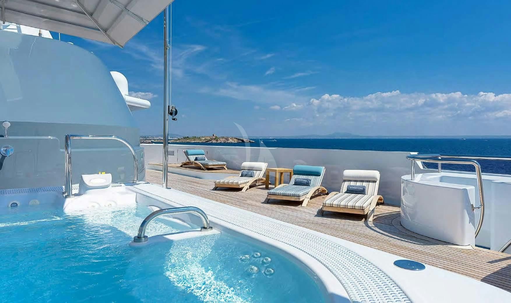 a large white boat on a blue water body aboard BOADICEA Yacht for Sale
