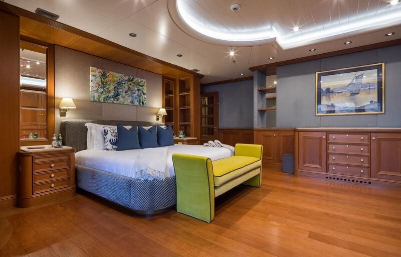 a bedroom with a bed and a desk aboard BOADICEA Yacht for Sale
