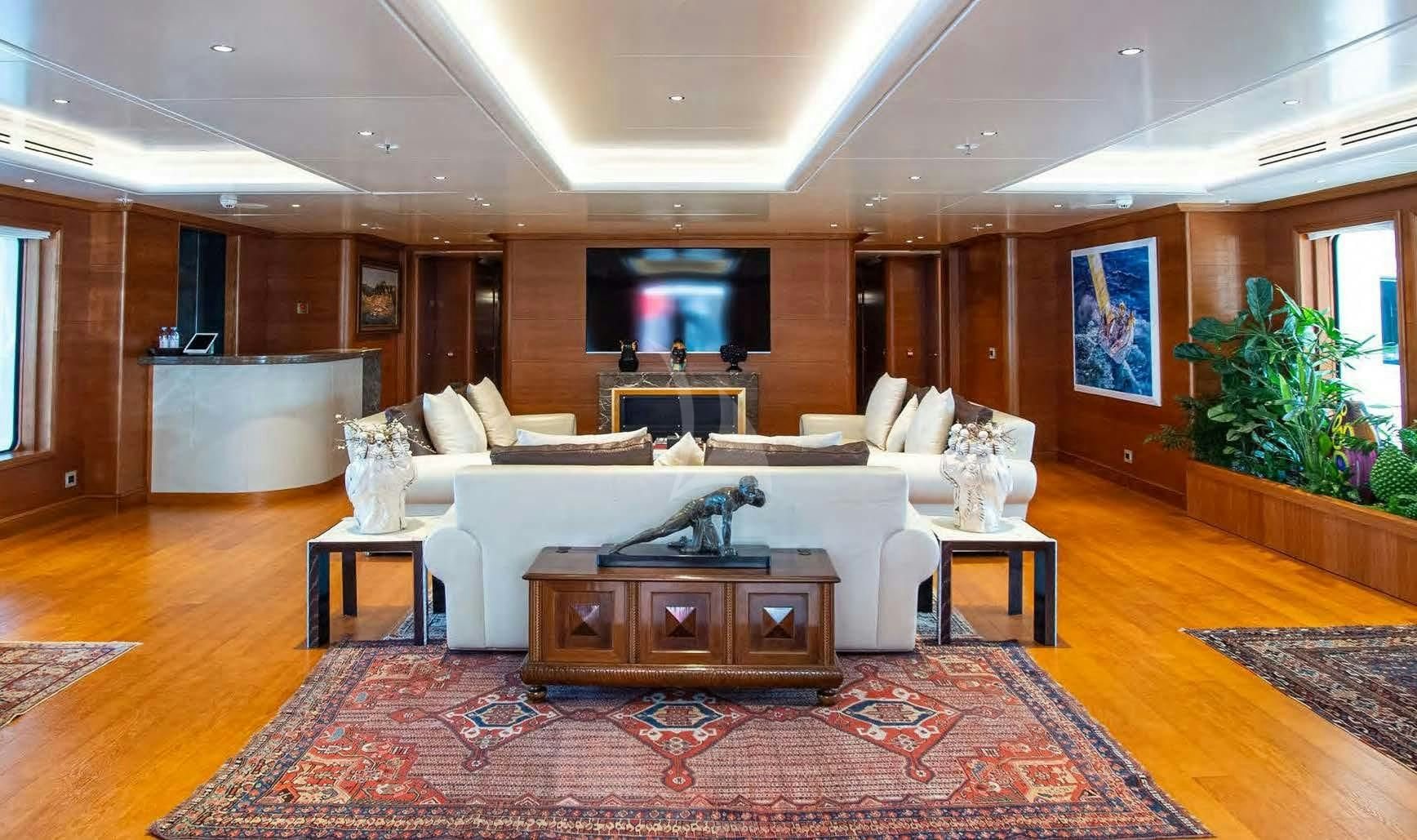 a large living room with a large red rug aboard BOADICEA Yacht for Sale