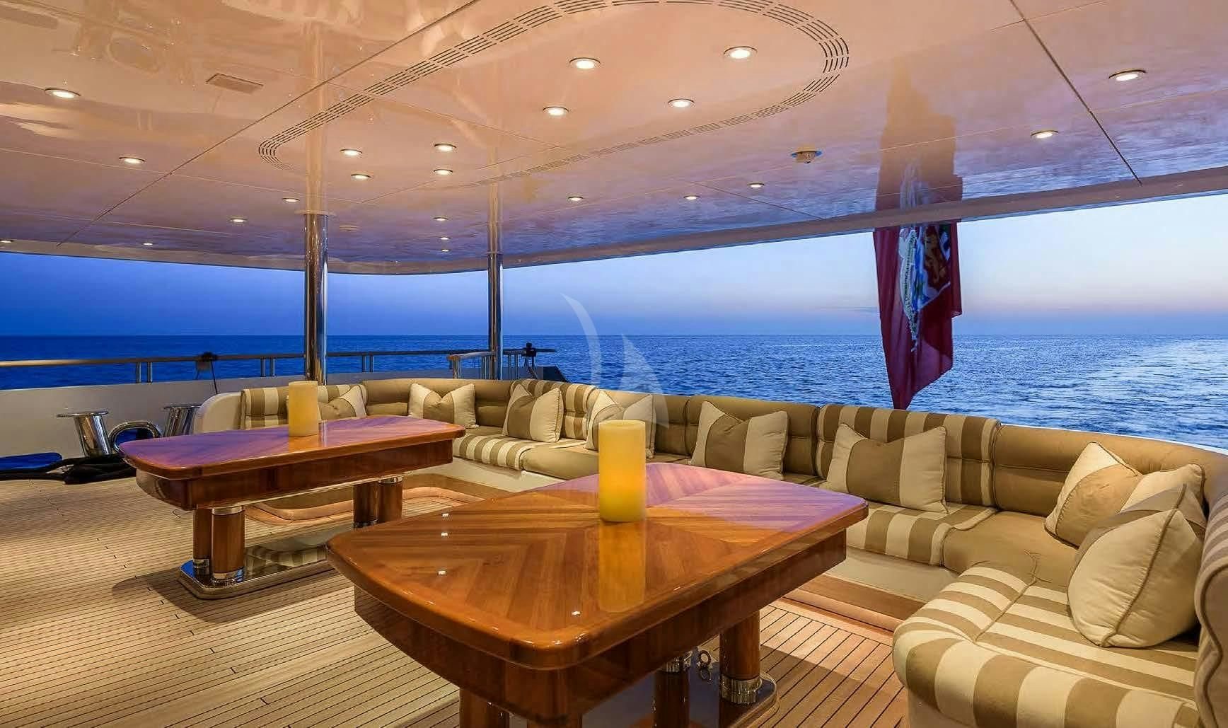 a room with a couch and a table and a table with a view of the ocean aboard BOADICEA Yacht for Sale