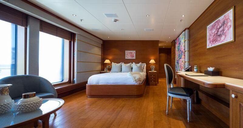 a bedroom with a bed and a desk aboard BOADICEA Yacht for Sale