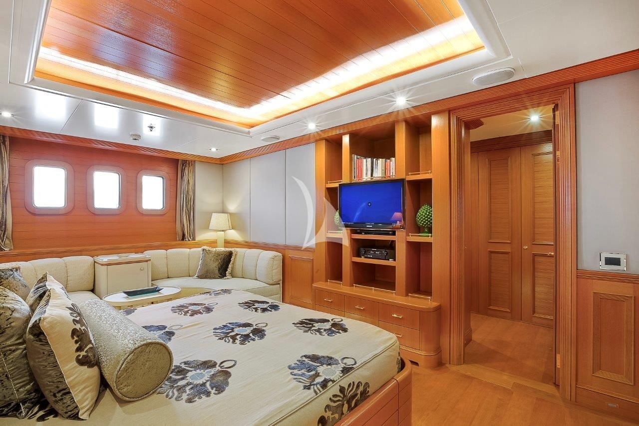 a bedroom with a bed and a tv on the wall aboard BOADICEA Yacht for Sale