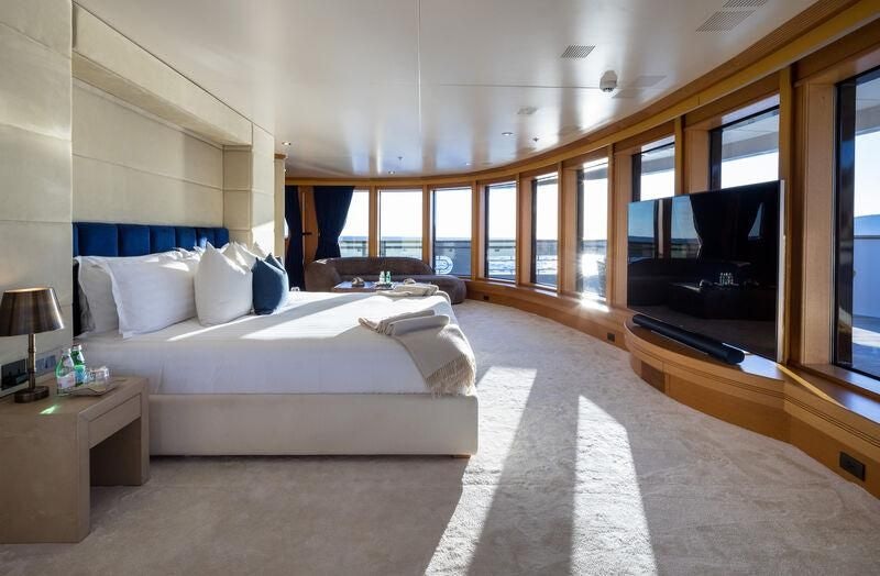 a hotel room with a bed and tv aboard BOADICEA Yacht for Sale