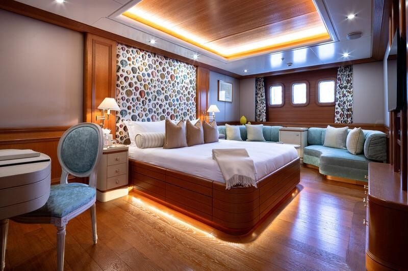 a large bedroom with a bed and a couch aboard BOADICEA Yacht for Sale