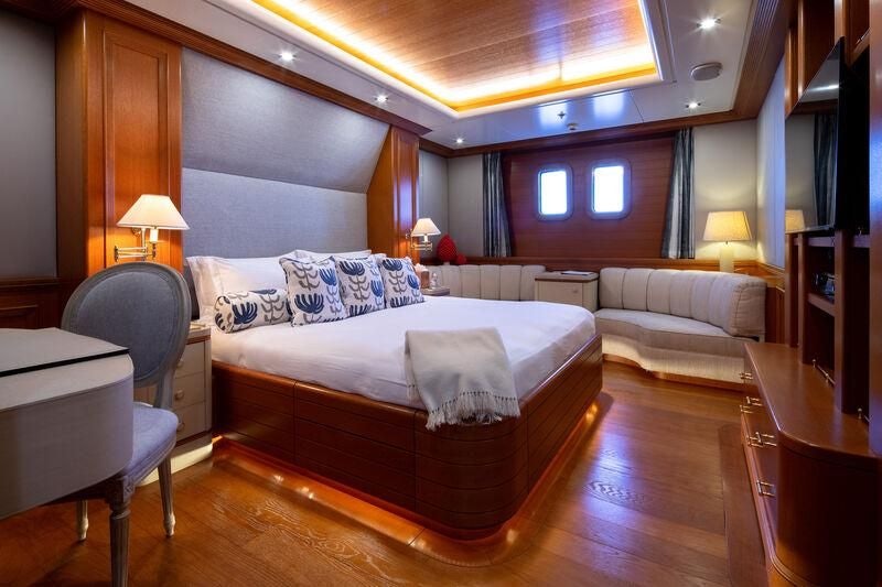 a large bedroom with a bed and a couch aboard BOADICEA Yacht for Sale