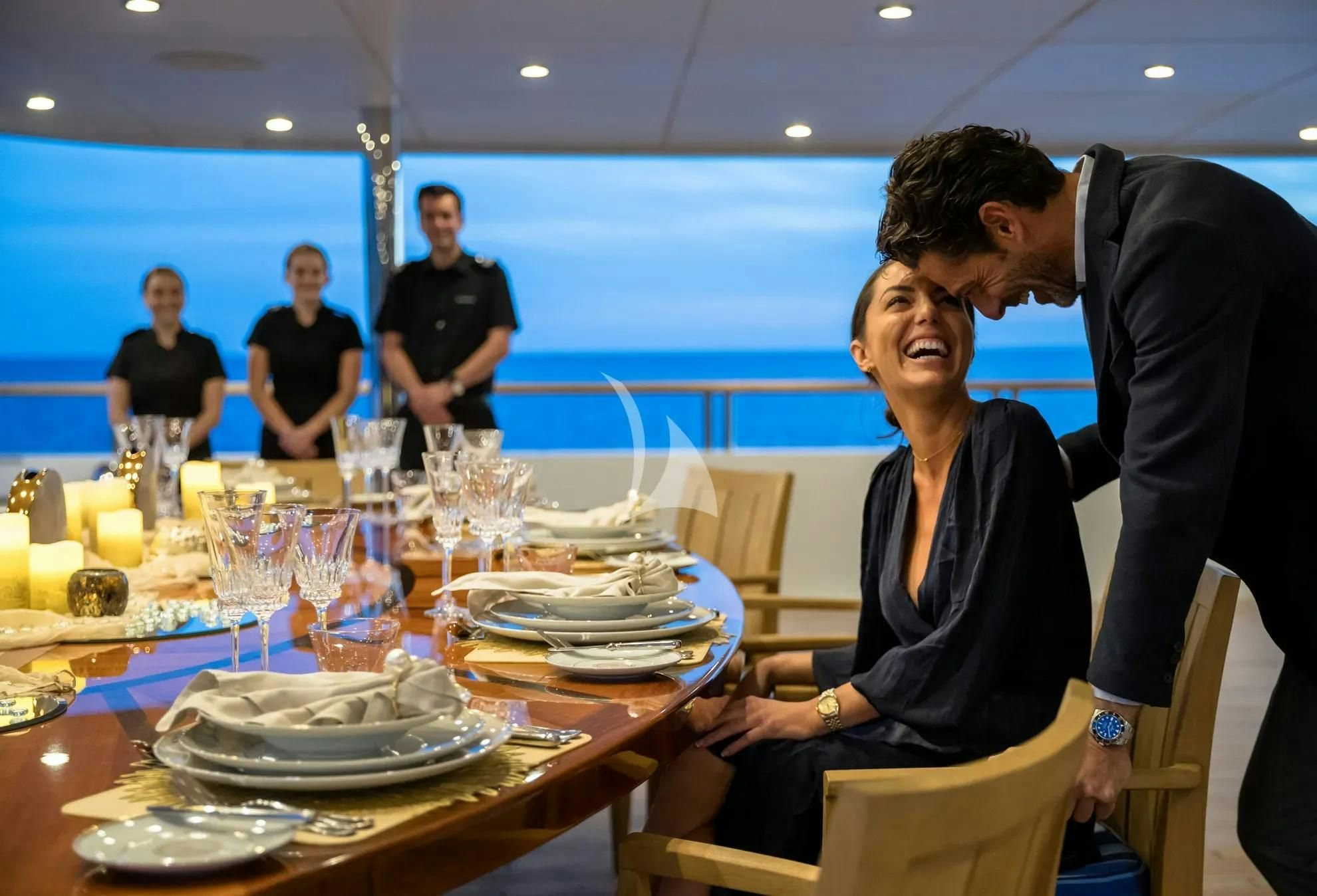 a man and woman sitting at a table with food and drinks aboard BOADICEA Yacht for Sale