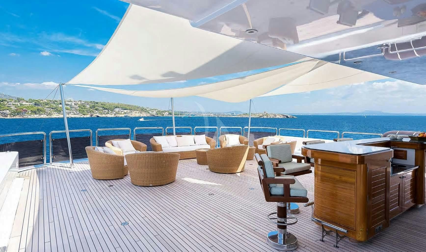 a deck with chairs and tables on it aboard BOADICEA Yacht for Sale