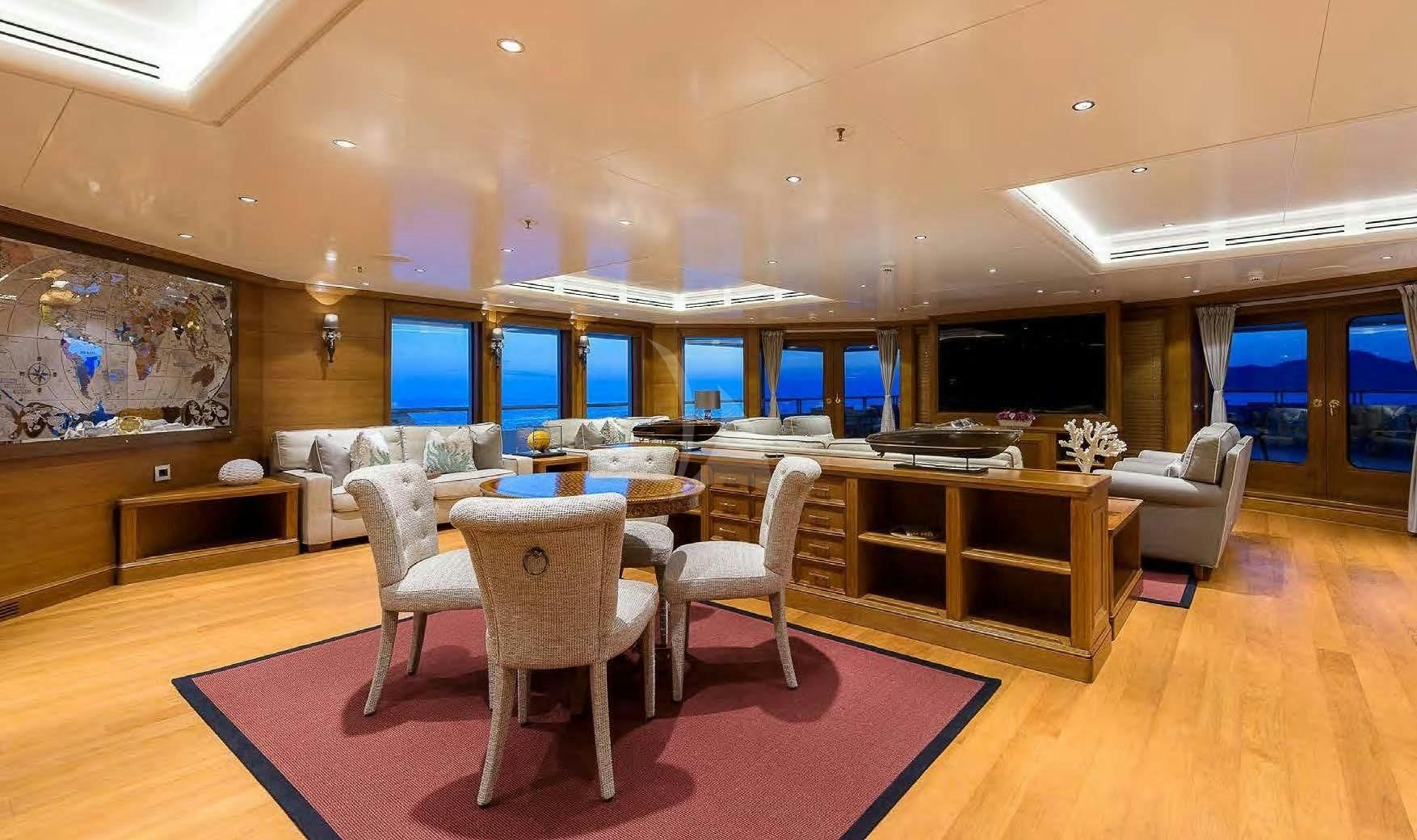 a room with a table chairs and a tv aboard BOADICEA Yacht for Sale