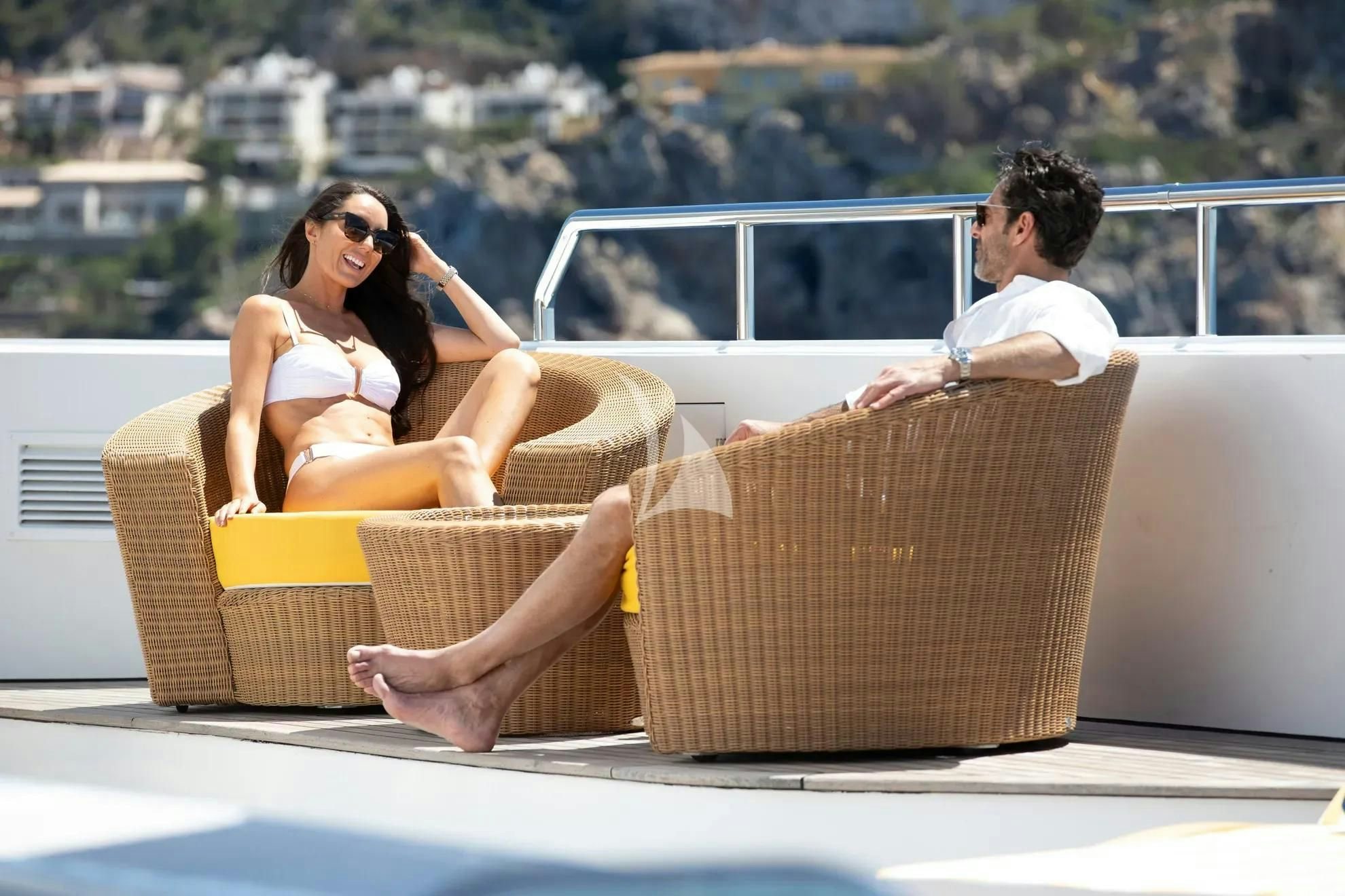a man and woman sitting on a couch aboard BOADICEA Yacht for Sale