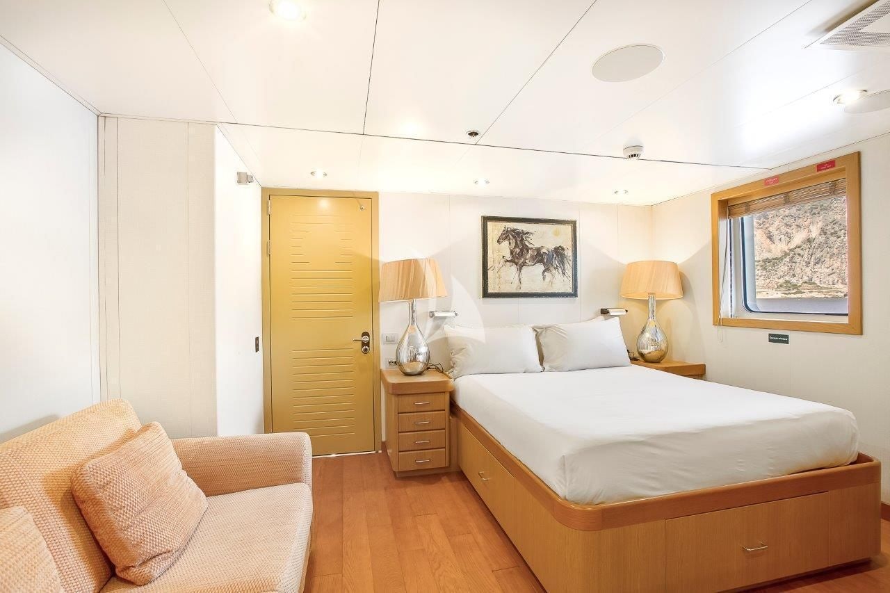 a bedroom with a bed and a couch aboard BOADICEA Yacht for Sale