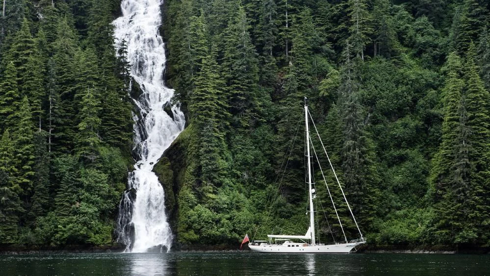 a sailboat in the water by a waterfall aboard FOFTEIN Yacht for Sale
