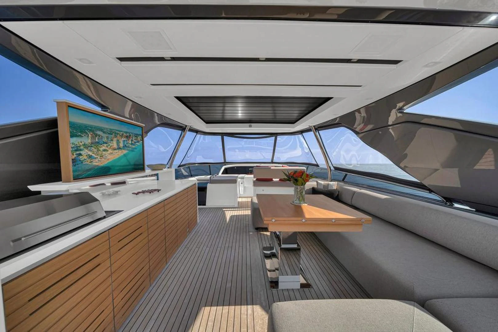inside of a vehicle with a large screen and a table with chairs and a television on it aboard JUJU Yacht for Sale