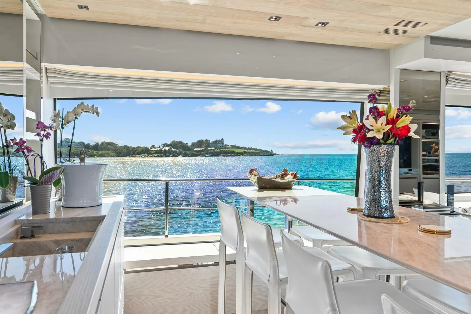 a table with chairs and a vase with flowers on it aboard JUJU Yacht for Sale