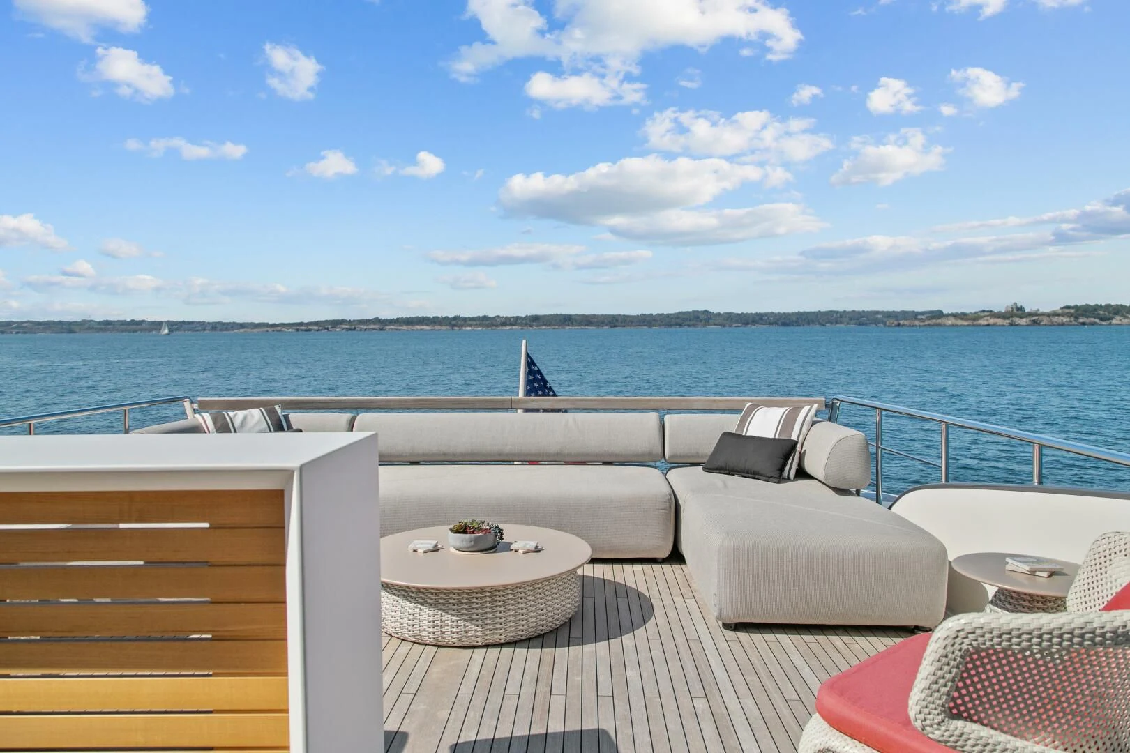 a deck with chairs and a table on it by the water aboard JUJU Yacht for Sale