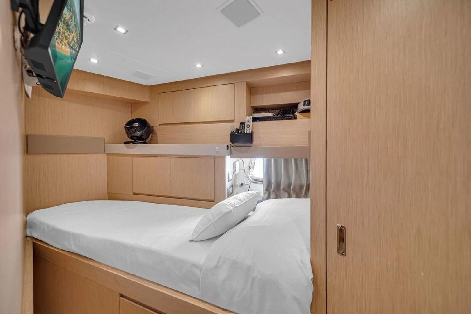 a small bedroom with a wood cabinet aboard JUJU Yacht for Sale