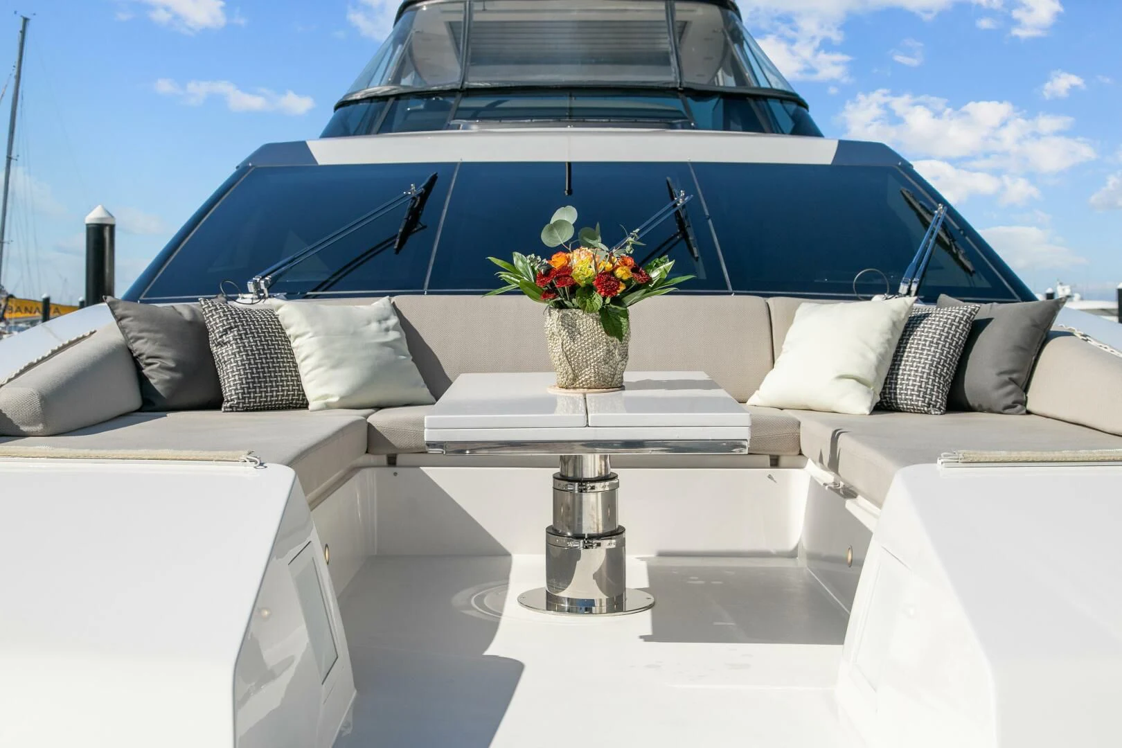 a white car with a white table and white seats and a vase with flowers in it aboard JUJU Yacht for Sale
