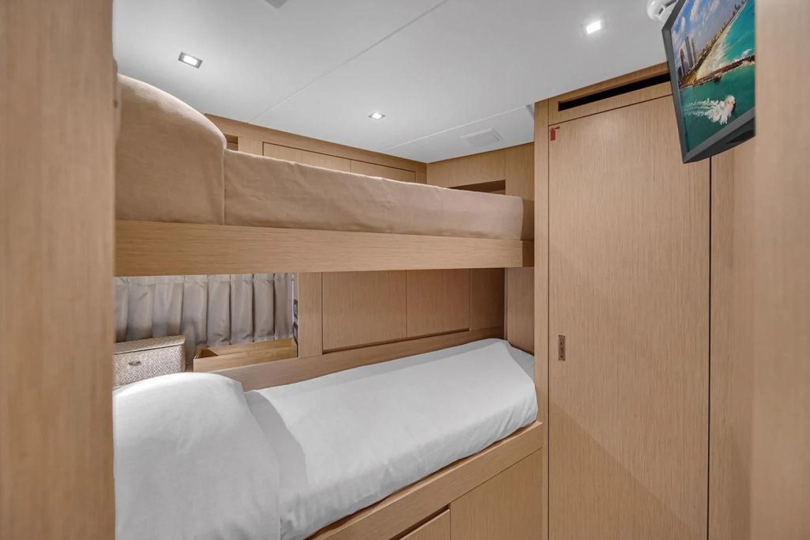a room with a bed and a wood cabinet aboard JUJU Yacht for Sale