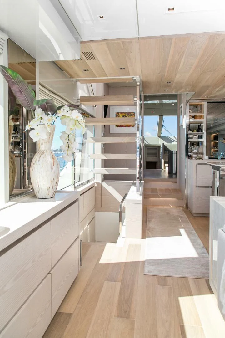 a room with a staircase and a vase with flowers aboard JUJU Yacht for Sale
